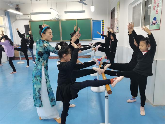 4月29日城固县龙头小学少年宫舞蹈社团的指导老师正在给学生们上形体课.jpg
