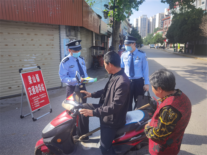 汉中市公安局指挥中心的干警在石拱社区纠正不文明交通行为并向发放电动车管理条例.jpg