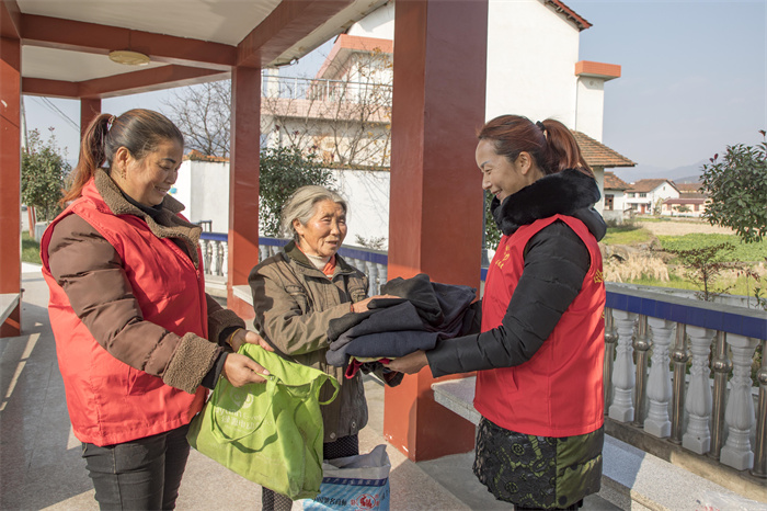 5留旗营社区老年协会志愿者为老人赠送衣物.jpg