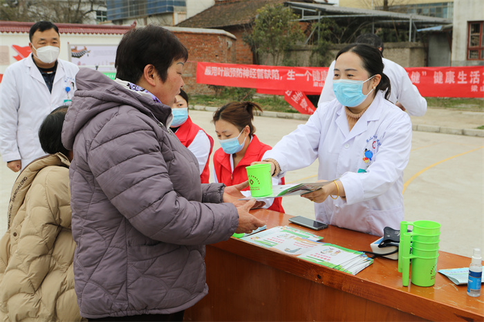 梁山镇中心卫生院的志愿者为群众发放签约医生宣传手册.jpg