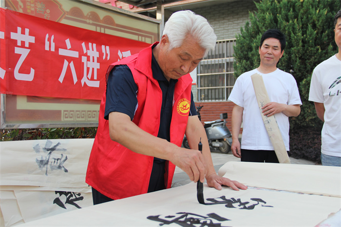 书法志愿者白新勇正在为群众赠写家风家训.jpg 书法志愿者白新勇正在为群众赠写家风家训.jpg