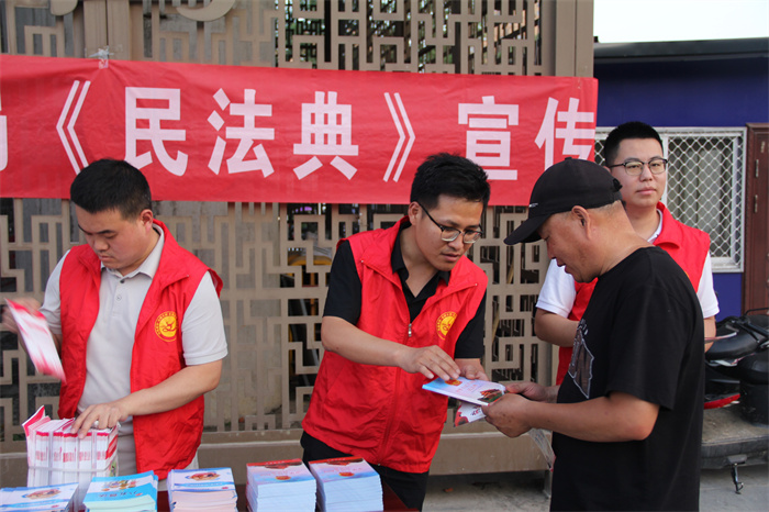 司法局法制宣传志愿者为群众发放《民法典》.jpg 司法局法制宣传志愿者为群众发放《民法典》.jpg